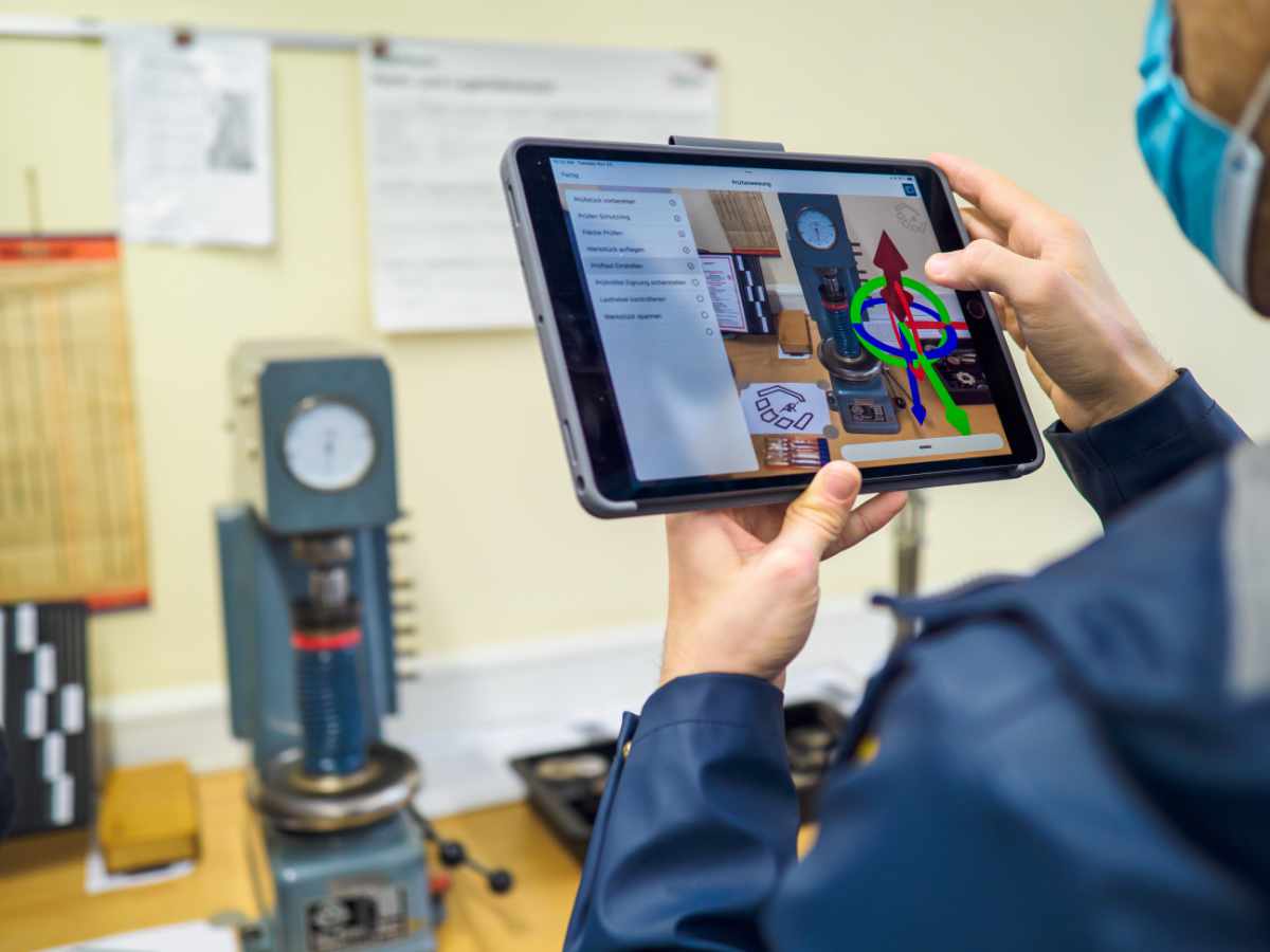 A participant using a tablet to place an AR hint on the machine